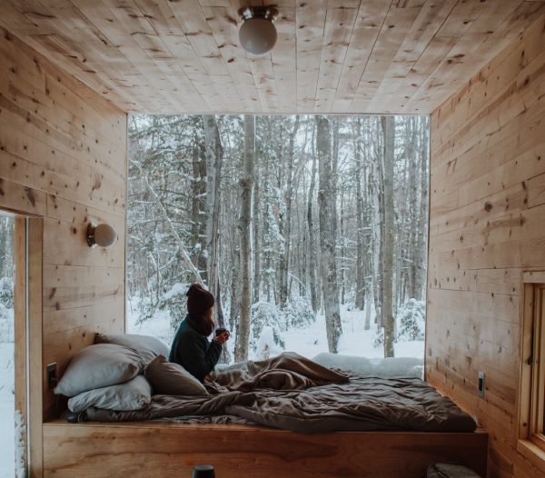 a woman getting cozy in a cabin during winter